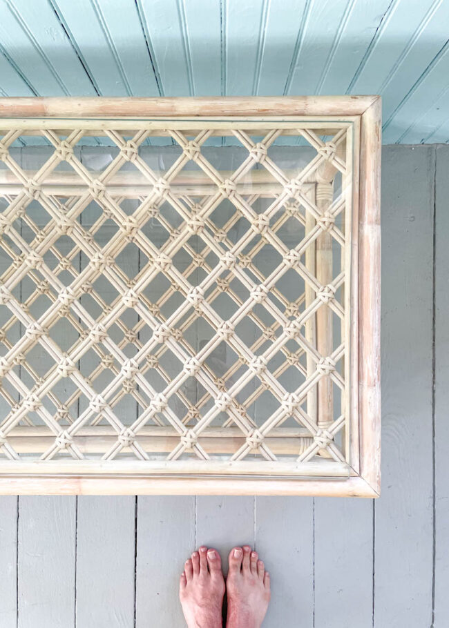 looking down at a glass table with multiple layers, artists barefoot feet at the edge of the photo