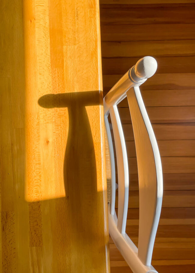looking down at a chair casting a shadow on a table